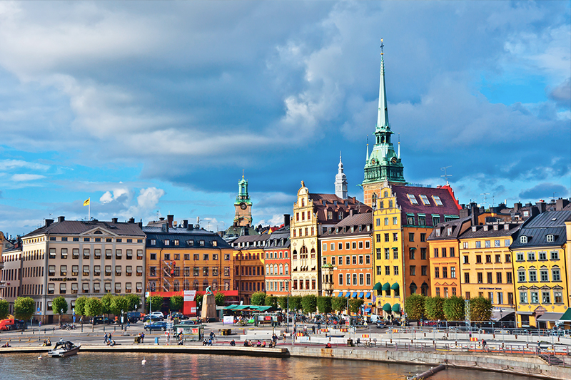 Stockholm Gamla Stan colourful builduings and blue sky in Stockholm harbour