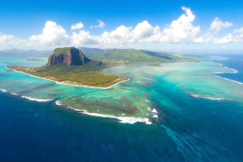 Aerial view of Mauritius with mountain and blue ocean.