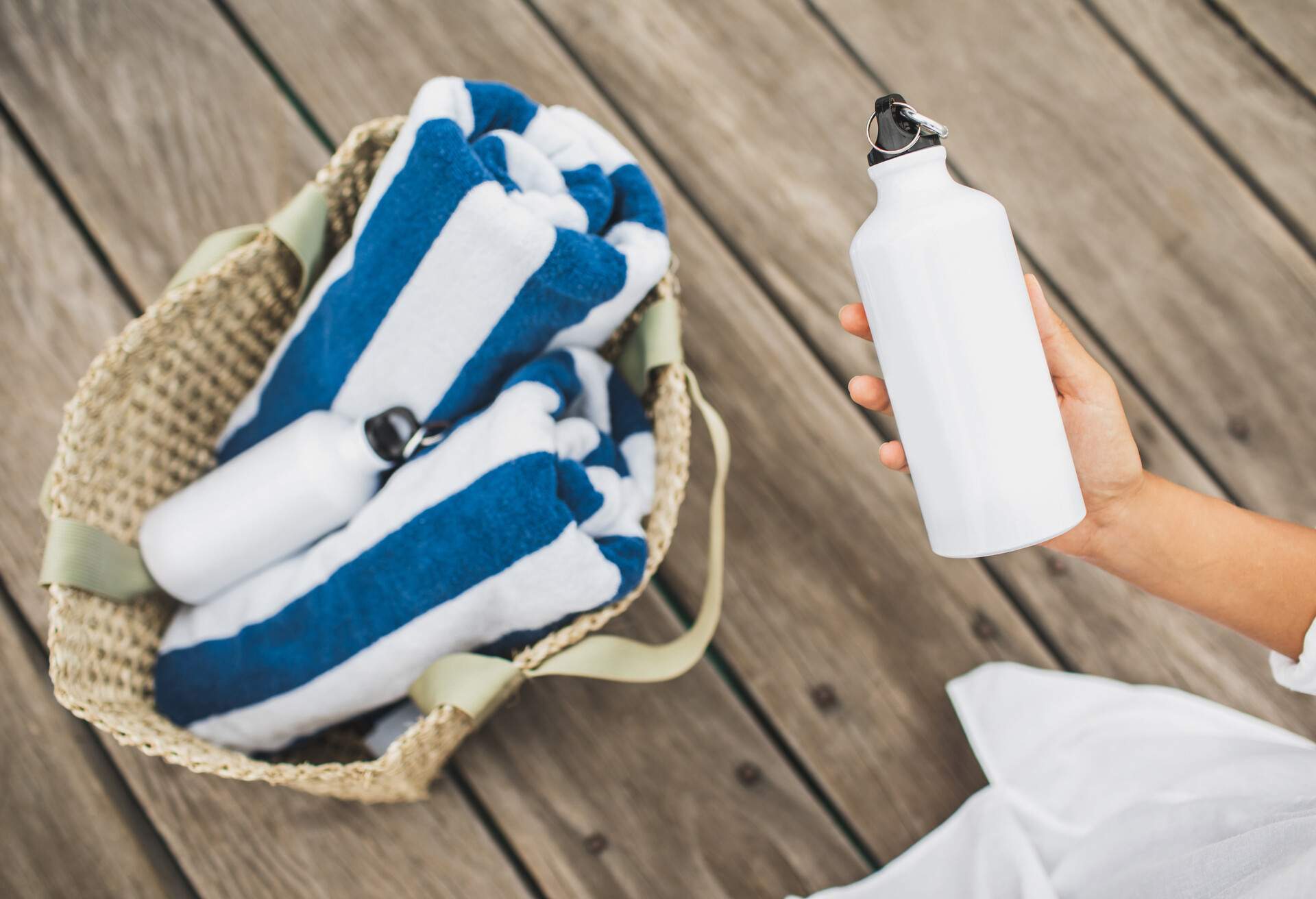 THEME_BEACH_BEACH-BAG_REUSABLE-BOTTLE_TOWEL_PACKING-GettyImages-1252803511